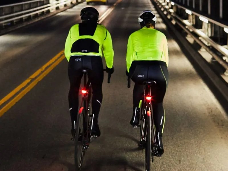 2 cyclistes de dos revêtus d'un gilet jaune de sécurité